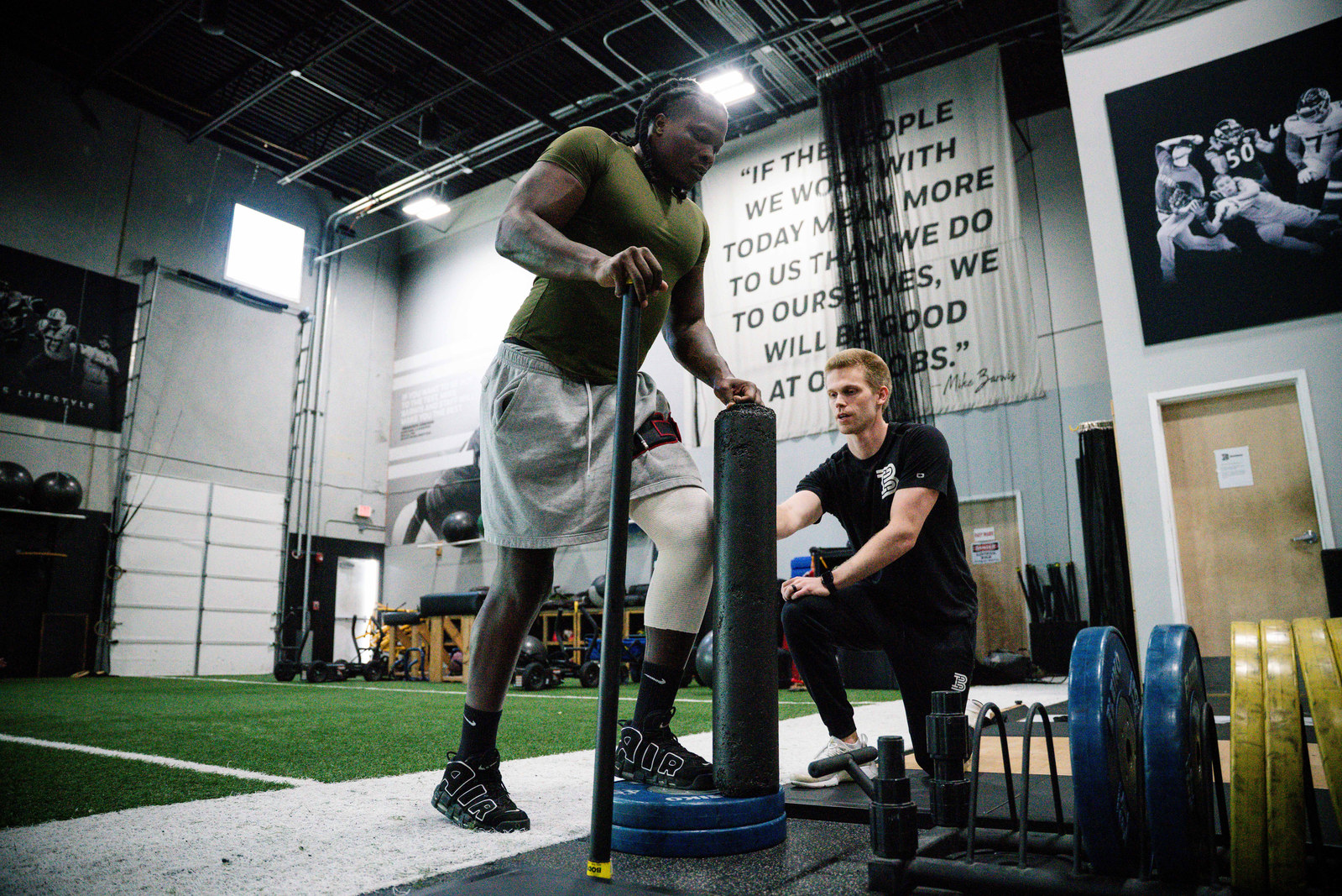 A Barwis physical therapist working with an athlete on turf